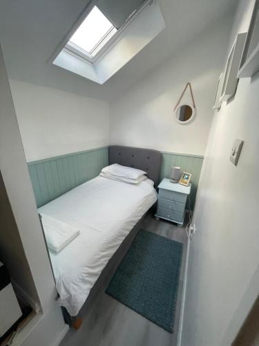 海尔20 Strawberry Hill cosy cottage sleeps 5的一间小卧室,配有床和窗户