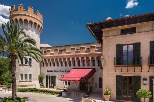 马略卡岛帕尔马Castillo Hotel Son Vida, a Luxury Collection Hotel, Mallorca - Adults Only的一座带钟楼和棕榈树的建筑