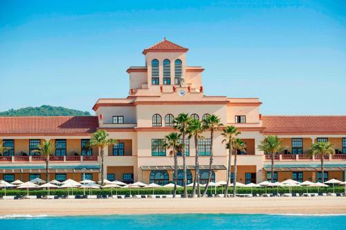 埃勒凡达尔艾美海滩水疗酒店的一座棕榈树环绕的大建筑