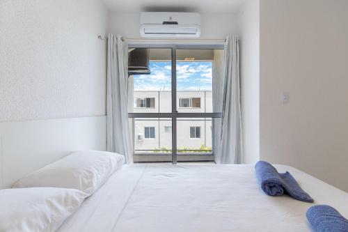 阿奎拉兹Beach Townhouses #C12 - Tríplex por Carpediem的卧室配有白色的床和窗户。