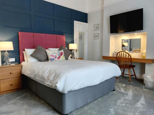 托基和谐住宿加早餐旅馆的一间卧室配有一张大床和红色床头板