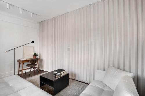 特拉维夫Charming by HolyGuest的客厅配有白色的沙发和桌子