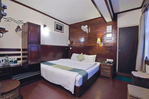 甘托克The Nettle and Fern Hotel Gangtok的一间卧室配有一张大床和一张书桌