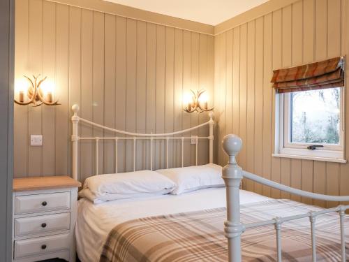 斯卡伯勒Grouse Lodge的卧室配有白色的床和窗户。