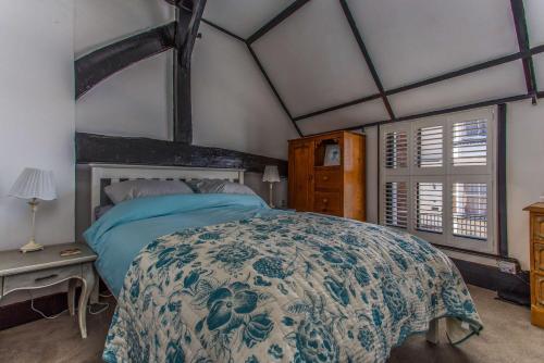 海斯廷斯Modern living, Charming Old Town Cottage的一间卧室配有一张带蓝色和白色床单的床。