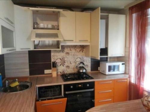 尼古拉耶夫Апартаменты Анжелика на Богоявленском проспекте的厨房配有炉灶和微波炉。