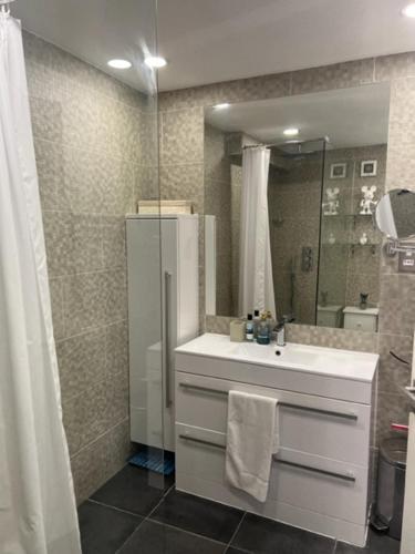 伦敦2 Bedroom Chelsea Apartment的浴室配有盥洗盆和带镜子的淋浴