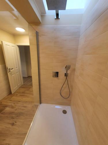 屈里茨Cafe Schröder Ferienwohnung的一间带淋浴的浴室,墙上装有软管