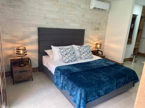 卡利Apartamento en Granada con piscina, turco, estacionamiento的一间卧室配有一张带蓝色毯子的大床