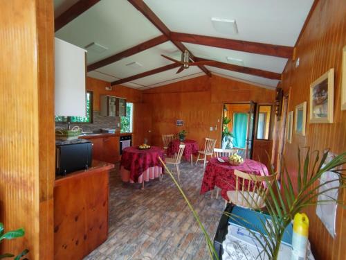 安加罗阿Hostal Makohe Rapa Nui的一间带两张桌子的客厅和一间厨房