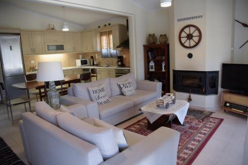 KondárainaLimnia Residence的一间带白色沙发的客厅和一间厨房