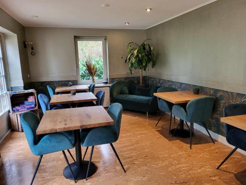 伊科斯特Herberg De Eexter Os的餐厅设有桌椅和沙发。