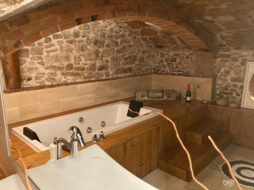 MoiàSuíte Sant Sebastià con jacuzzi, sauna y jardín的带浴缸和石墙的厨房