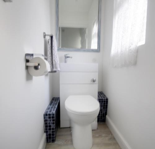 LexdenWinstree Road的白色的浴室设有卫生间和水槽。