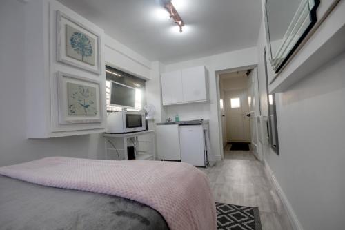 LexdenWinstree Road的一间白色卧室,配有床和厨房