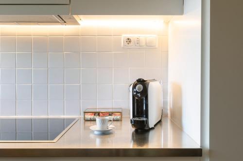 波尔图波尔特拉之家城市公寓酒店的厨房的柜台上配有咖啡机
