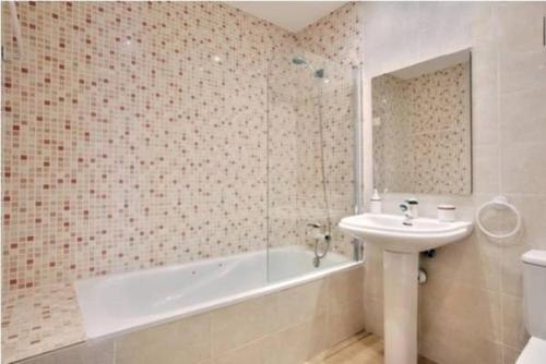隆达龙达市中心公寓的带浴缸、水槽和浴缸的浴室