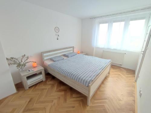 米库洛夫Apartmán Pod zámkem的一间铺有木地板的白色卧室,配有一张床