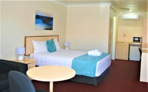 阿米代尔阿米代尔俱乐部汽车旅馆的酒店客房配有一张床铺和一张桌子。
