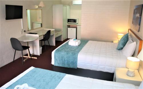 阿米代尔阿米代尔俱乐部汽车旅馆的酒店客房配有一张床、一张书桌和一间厨房。