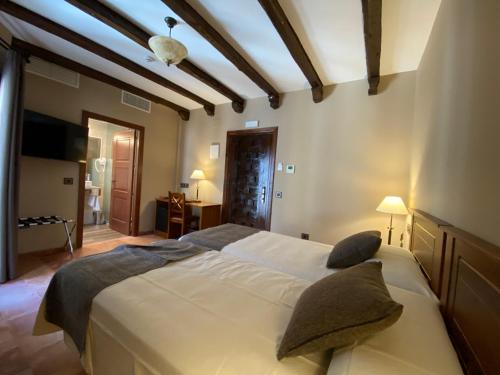 Perales de TajuñaHotel Rural El Lagar de Nemesio的一间卧室配有一张大床和枕头