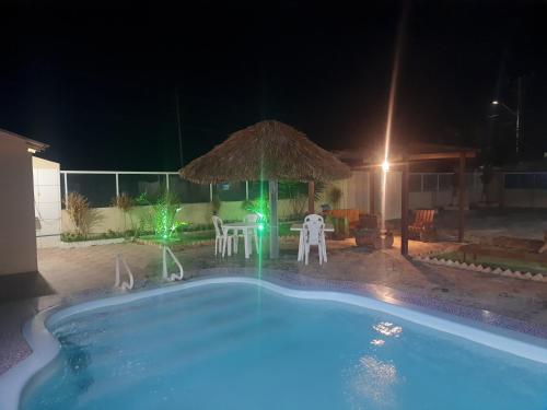 路易斯科雷亚pousada ATALAIA ASFEPI的游泳池在晚上配有桌椅