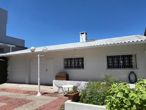 拉热斯Norte Hospedagem的白色的房子,配有两把椅子和一张桌子