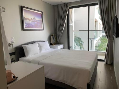 绥和市Toà Nhà Apec Mandala Wyndham Phú Yên的酒店客房设有一张床和一个大窗户
