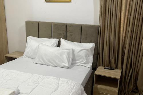 拉各斯Beautiful 2Br Apt in Ogba, Ikeja, Lagos的一间卧室配有带白色床单和枕头的床。