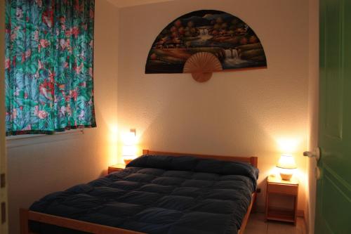 莫列马阿Moliets plage, Résidence OPEN SUD的一间卧室配有一张带两盏灯和一幅画的床铺