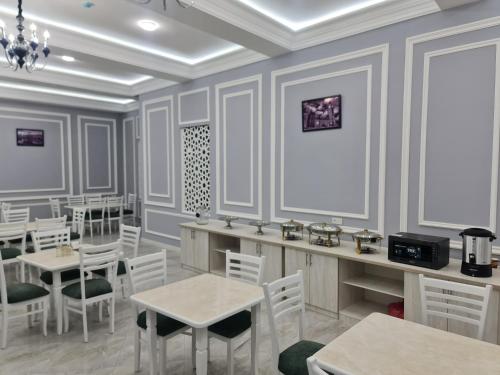 撒马尔罕OLD STATION HOTEL的一间设有白色桌椅的用餐室
