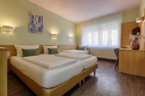 维尔茨堡Hotel Kunterbunt - by homekeepers的酒店客房配有两张床和一张书桌
