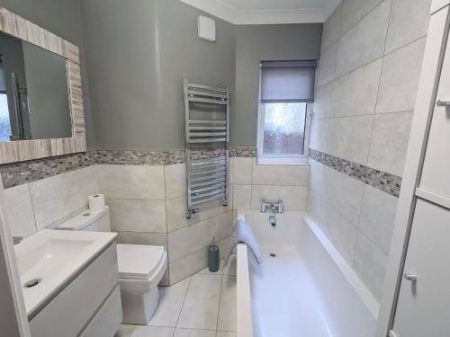 滨海绍森德Lincoln Lodge, 2-bedroom,2-bathroom,ground floor flat的带浴缸、卫生间和盥洗盆的浴室