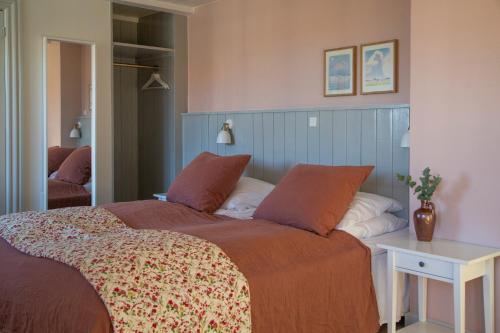 凡岛Fanø Krogaard的一间卧室配有一张大床和一张桌子