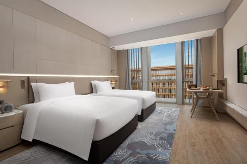 宁波Wonderland Hotel Ningbo International Conference Center的酒店客房设有两张床和一个阳台。