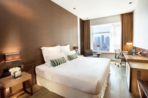 香港Nina Hotel Kowloon East的酒店客房设有一张大床和一张书桌。