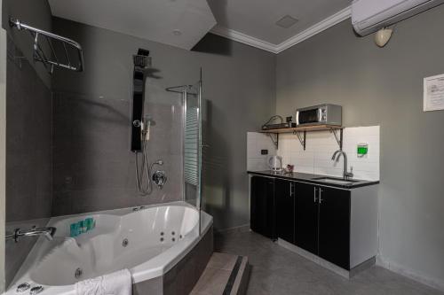 特拉维夫Residence Suites BY RAPHAEL HOTELS的带浴缸和盥洗盆的浴室