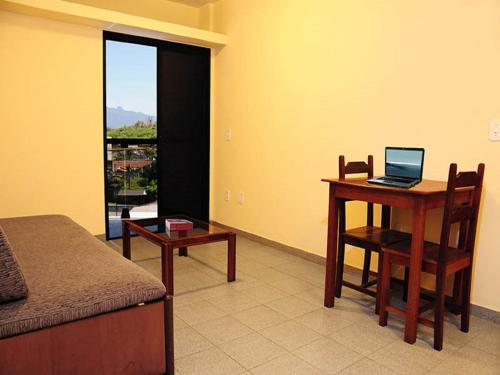 雷森迪Scala Residence Hotel的一间卧室配有书桌和一台笔记本电脑(桌子)