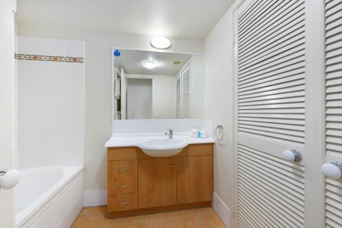 黄金海岸BEST Ground Floor pool side Superior apartment - new listing的一间带水槽、浴缸和镜子的浴室
