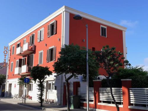 圣安蒂奥科意大利餐厅摩登酒店的街道上的一座橙色和白色的建筑