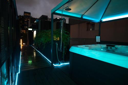 新加坡Hotel NuVe Elements的一间带浴缸的浴室,在晚上在阳台上