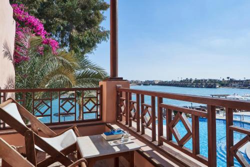 赫尔格达苏丹贝度假酒店的阳台配有桌椅和水