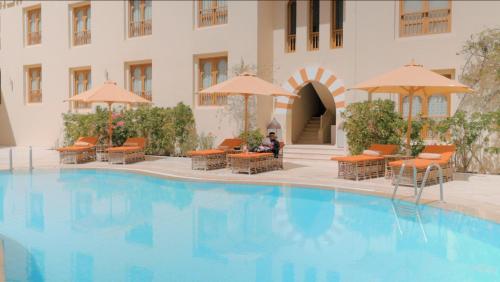 赫尔格达阿里帕夏酒店的酒店设有一个大型游泳池,配有椅子和遮阳伞