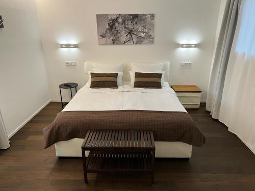 梅灵奥林格酒庄-公寓式酒店的卧室配有一张带两个枕头的大白色床
