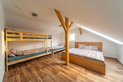 SkutečChaloupka Borůvka的铺有木地板的客房内配有两张双层床。