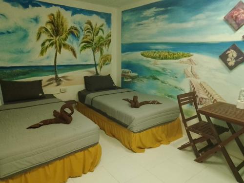 皮皮岛Reggaeinn的墙上画画的房间里设有两张床