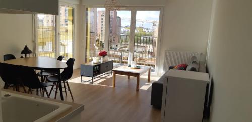 巴纽La Terrasse - big apartment & terrace 80m2 - metro 17 min from Paris的客厅配有桌椅和大窗户