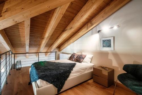 梅纳焦Il Castello - by MyHomeInComo的一间带一张床的卧室,位于带木制天花板的房间内
