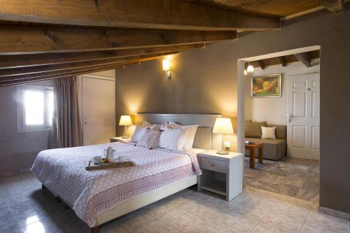 梅加利阿莫斯Nimfi Hotel, Skiathos的一间卧室配有一张带白色床罩的大床