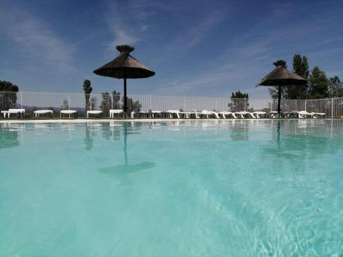 格罗斯皮耶尔雷Domaine des Garrigues的一个带遮阳伞和椅子的大型游泳池